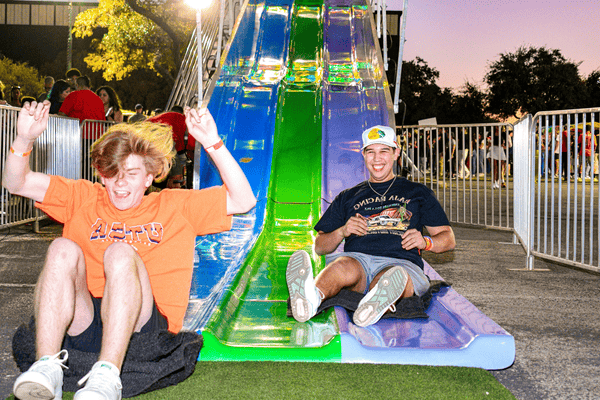 two students coming down the slide